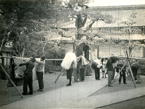 寺院の境内で布団を干している子どもたちの写真