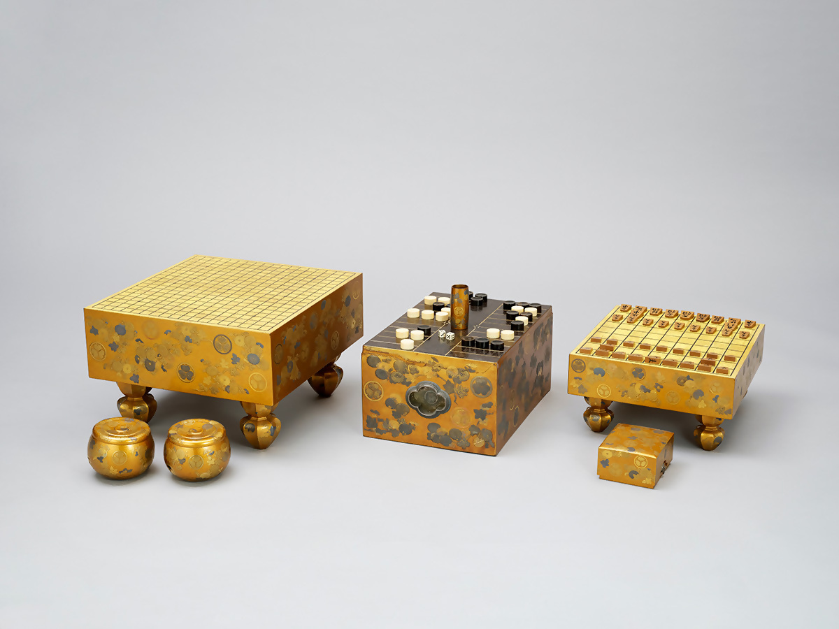 金蒔絵で菊の模様がいれられた碁盤とすごろく盤と将棋盤の画像