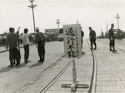 橋の真ん中に置かれた立て札の白黒写真