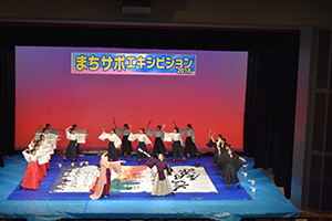 舞台で高校生たちが大きな作品をつくるところ