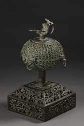 透かし彫り状の台座が付き、頂部に鳥が装飾された香炉