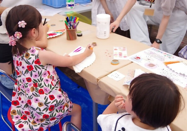 扇に筆ペンで絵付けをする参加者