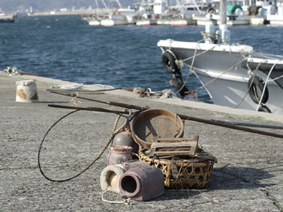 漁港にたこ壺などの漁具を並べてある写真